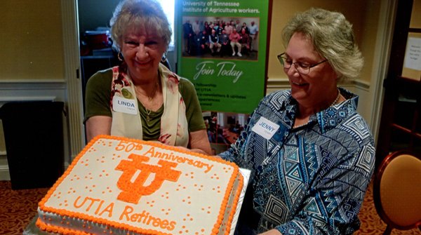 Retirees members celebrate with orange and white cake