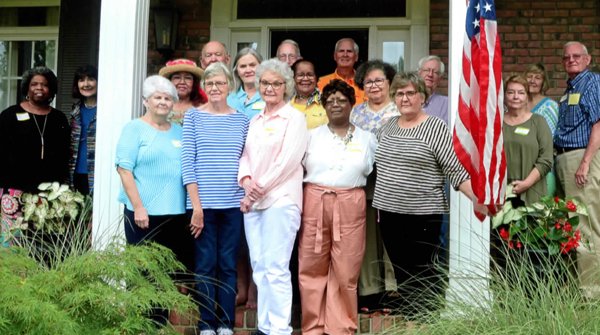 Group of retirees stands on a porch